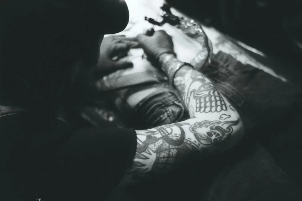 Tatuador profesional realizando diversos estilos de tatuaje.