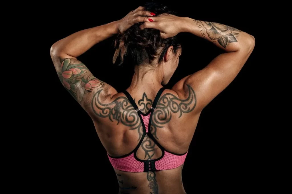 Mujer deportista con tatuajes en su cuerpo.