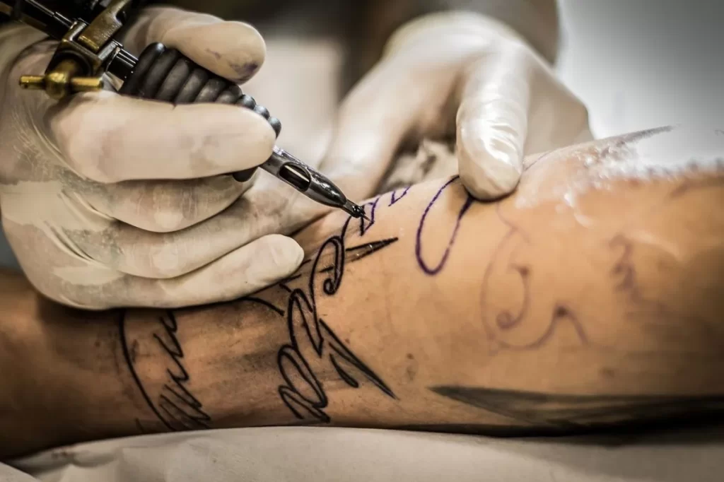 Tatuador profesional cubriendo un tatuaje antiguo