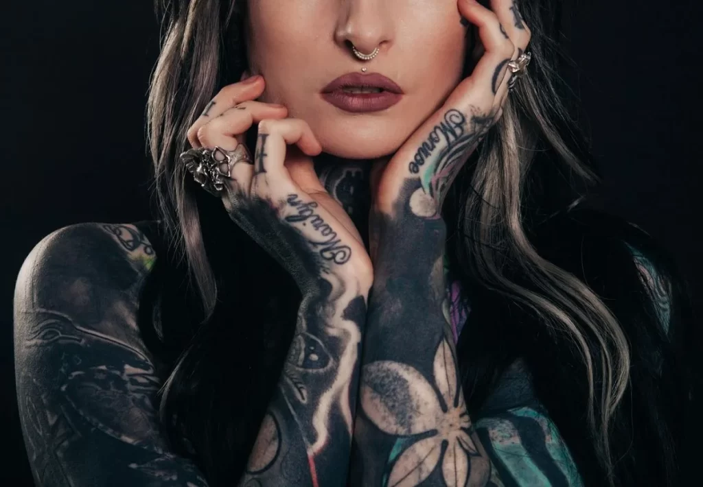 Mujer modelo con tatuajes de diferentes estilos combinados.